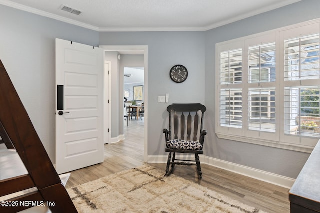 living area featuring wood finished floors, visible vents, and baseboards