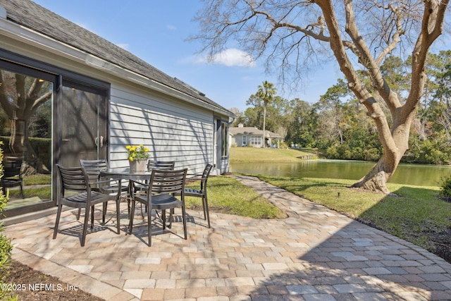 view of patio with a water view and outdoor dining space