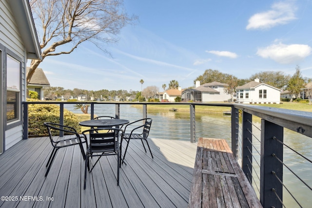 wooden terrace with a water view and a residential view