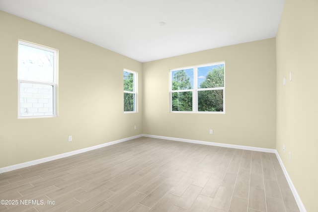 spare room featuring light wood-style flooring and baseboards