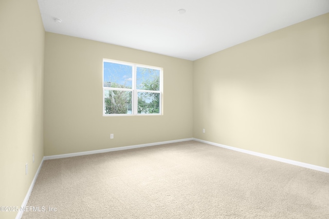 carpeted spare room with baseboards