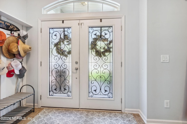 foyer entrance featuring french doors and baseboards