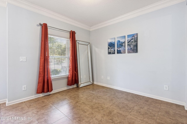 spare room with baseboards and crown molding