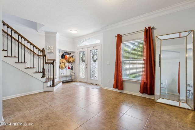 tiled foyer entrance with french doors, crown molding, stairway, and a textured ceiling