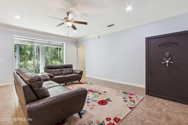 living area with arched walkways, ceiling fan, visible vents, baseboards, and ornamental molding