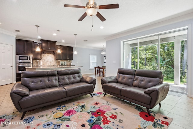 living room with light tile patterned floors, a textured ceiling, a ceiling fan, and crown molding