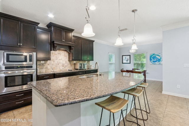 kitchen with light tile patterned floors, decorative backsplash, stainless steel appliances, crown molding, and a sink