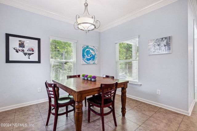 dining space with baseboards, ornamental molding, plenty of natural light, and an inviting chandelier