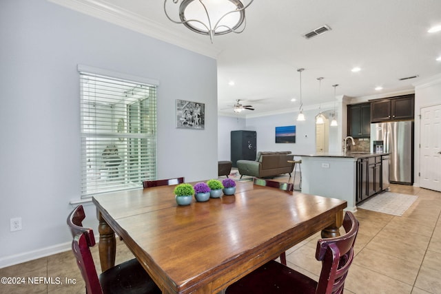 dining room featuring light tile patterned floors, a ceiling fan, visible vents, and crown molding