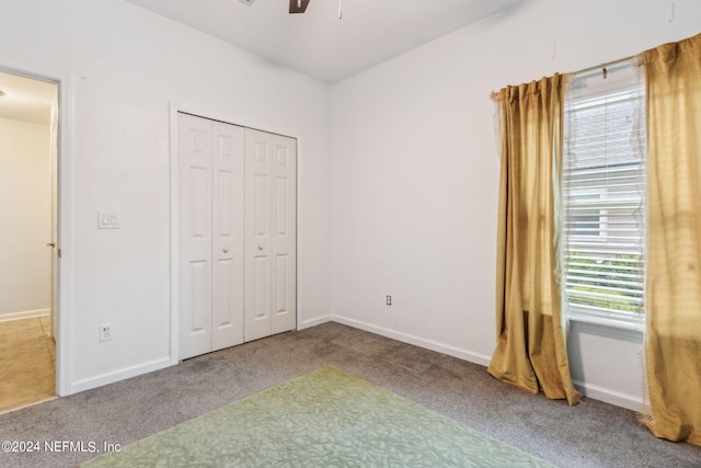 unfurnished bedroom with a closet, carpet flooring, and baseboards