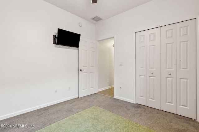 unfurnished bedroom featuring carpet floors, a closet, visible vents, and baseboards