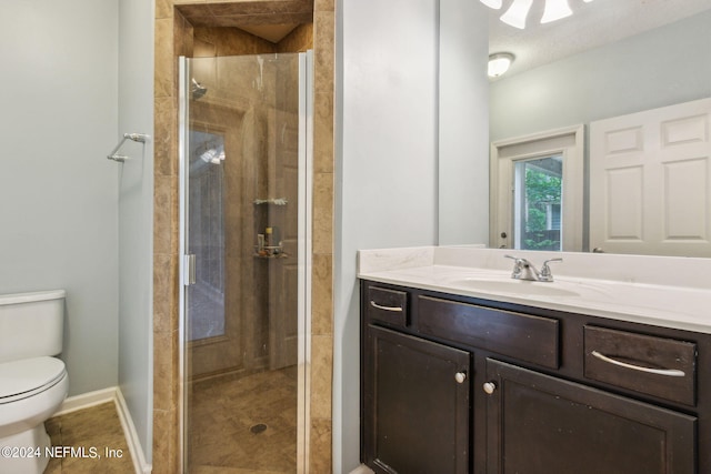 bathroom with toilet, a stall shower, vanity, tile patterned flooring, and baseboards