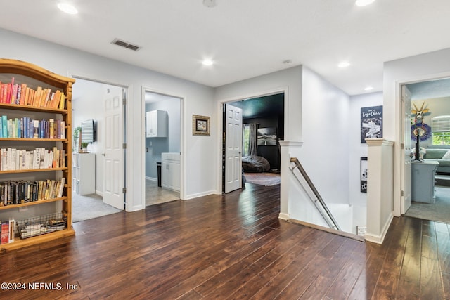 hall featuring visible vents, baseboards, hardwood / wood-style flooring, an upstairs landing, and recessed lighting