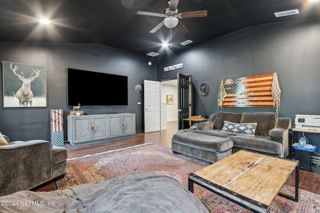 living room with lofted ceiling, wood finished floors, visible vents, and a ceiling fan