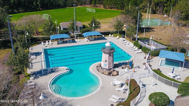 community pool with a patio area and fence