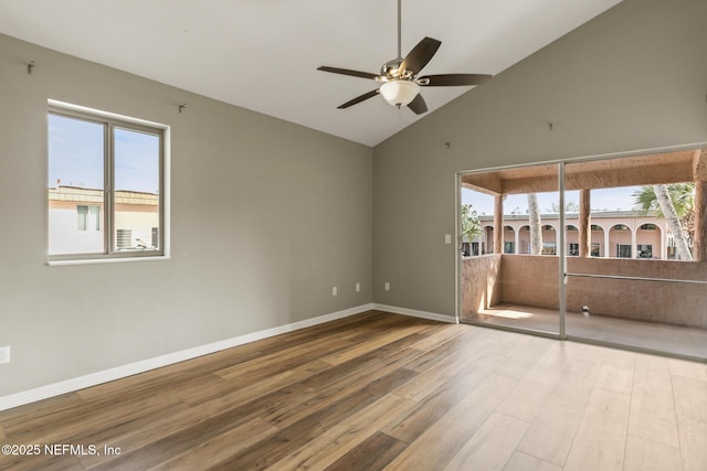 unfurnished room with high vaulted ceiling, ceiling fan, baseboards, and wood finished floors