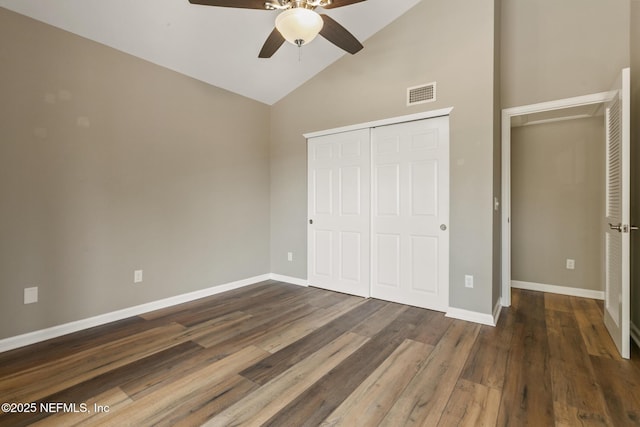 unfurnished bedroom with a closet, visible vents, ceiling fan, wood finished floors, and baseboards