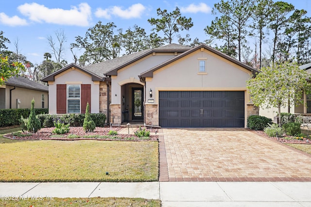 view of front of house with a garage, stone siding, decorative driveway, a front lawn, and stucco siding