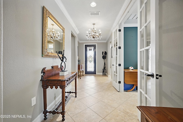 foyer featuring light tile patterned floors, visible vents, ornamental molding, french doors, and an inviting chandelier