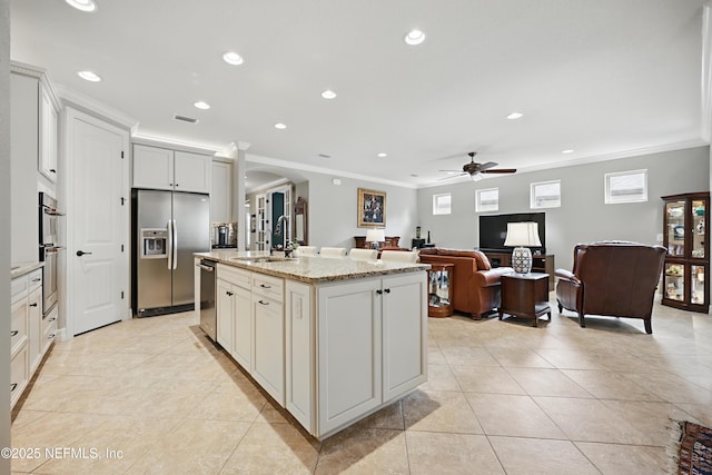 kitchen with stainless steel appliances, arched walkways, crown molding, and a sink