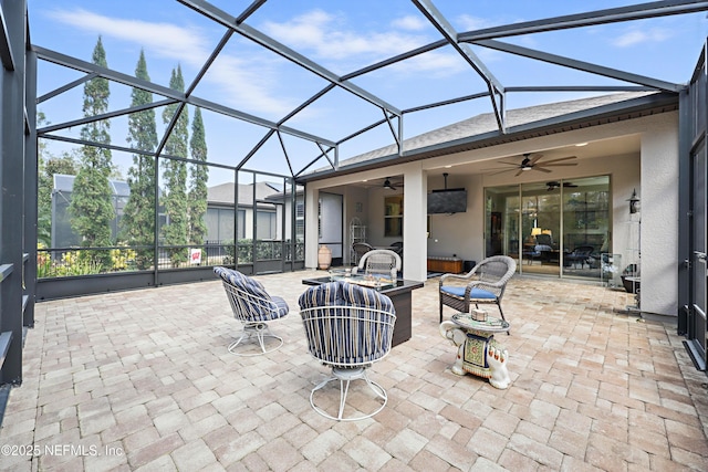 view of patio / terrace with a ceiling fan and glass enclosure