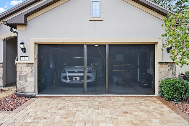 garage with decorative driveway