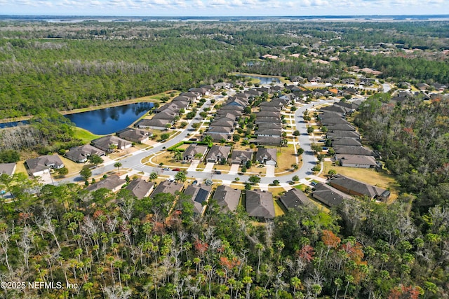 drone / aerial view with a water view, a residential view, and a view of trees