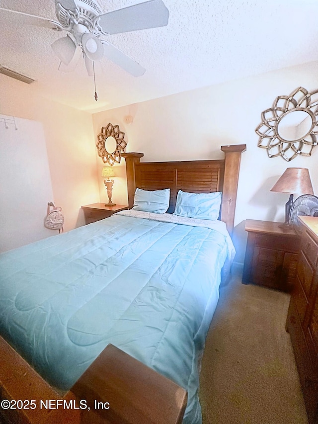 carpeted bedroom with ceiling fan and a textured ceiling