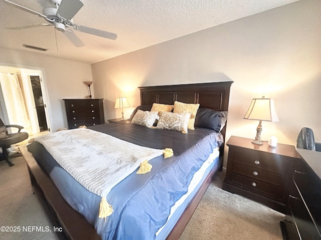 bedroom with light colored carpet, ceiling fan, visible vents, and a textured ceiling