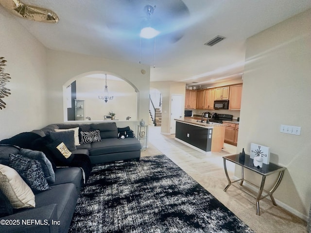 living room with stairs, arched walkways, and visible vents