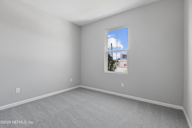 carpeted spare room featuring baseboards