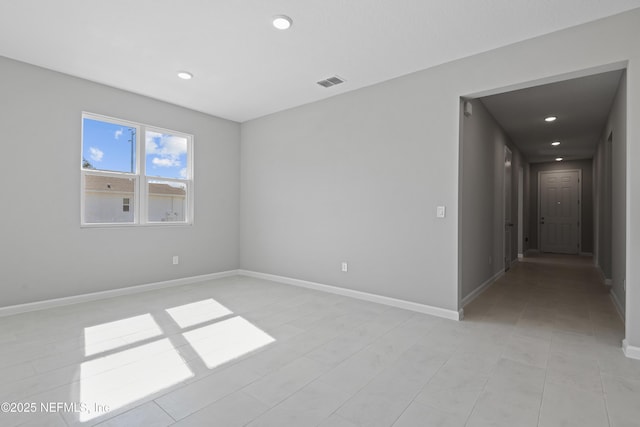 empty room with recessed lighting, visible vents, and baseboards