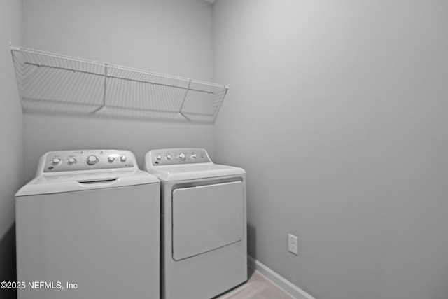 laundry area featuring laundry area, baseboards, and washing machine and clothes dryer