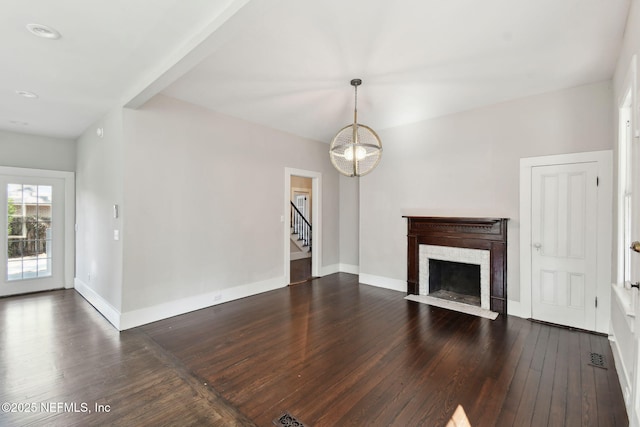 unfurnished living room featuring a high end fireplace, dark wood finished floors, baseboards, and stairs