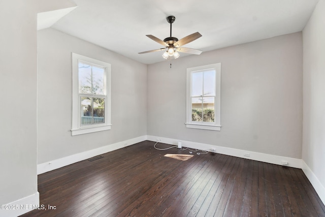 spare room with visible vents, baseboards, and hardwood / wood-style flooring