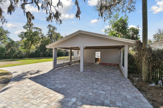 exterior space featuring a carport and decorative driveway