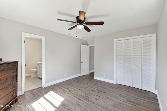 unfurnished bedroom featuring visible vents, baseboards, ensuite bath, light wood-style floors, and a closet