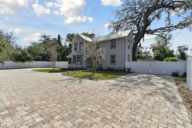 view of front of home with driveway, a gate, and fence