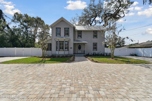 view of front of house with a front lawn, fence, and a gate