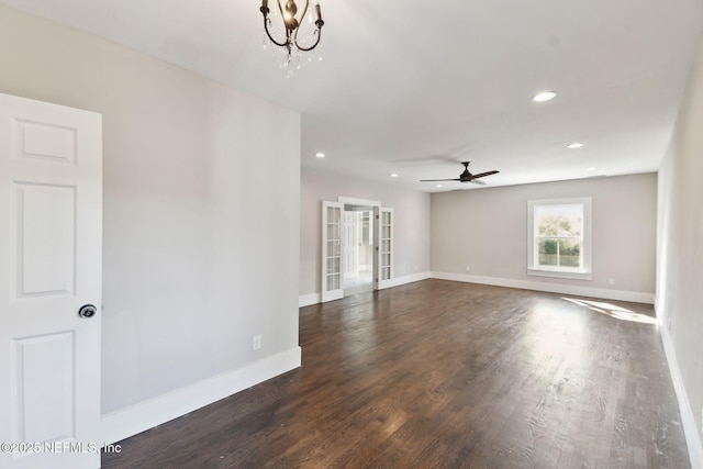 empty room with dark wood-style floors, ceiling fan with notable chandelier, baseboards, and recessed lighting