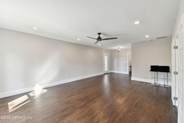 unfurnished living room with recessed lighting, dark wood-style flooring, visible vents, and baseboards