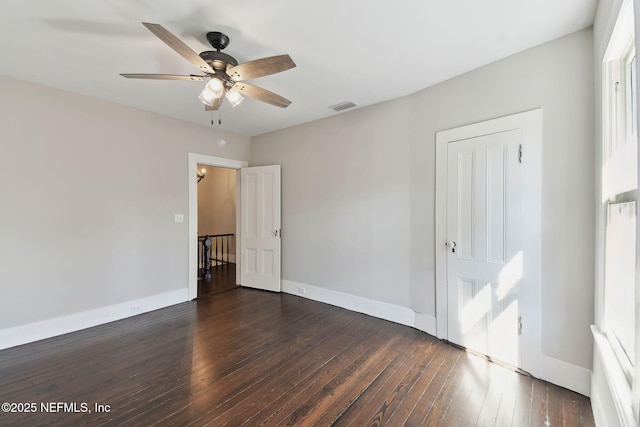 unfurnished bedroom with ceiling fan, dark wood finished floors, visible vents, and baseboards