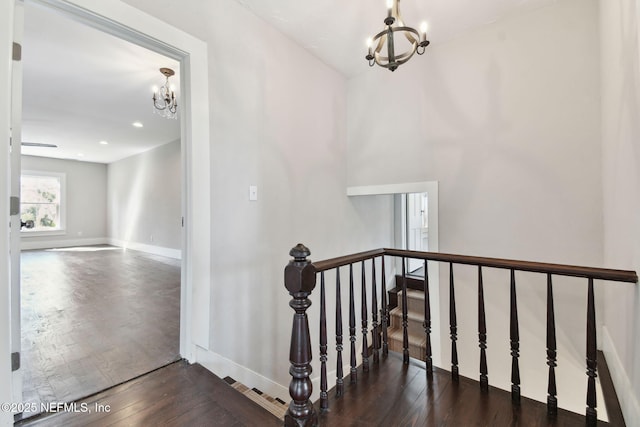 stairs with baseboards, visible vents, a notable chandelier, and hardwood / wood-style floors