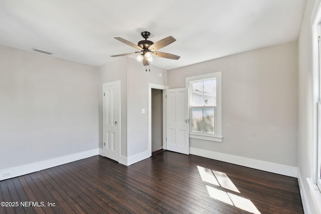 unfurnished bedroom with ceiling fan, dark wood-type flooring, visible vents, and baseboards