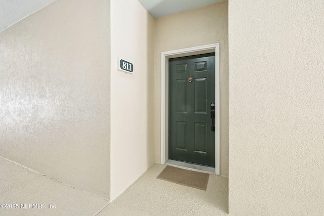 entrance to property featuring stucco siding