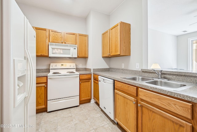 kitchen with white appliances, light tile patterned floors, and a sink