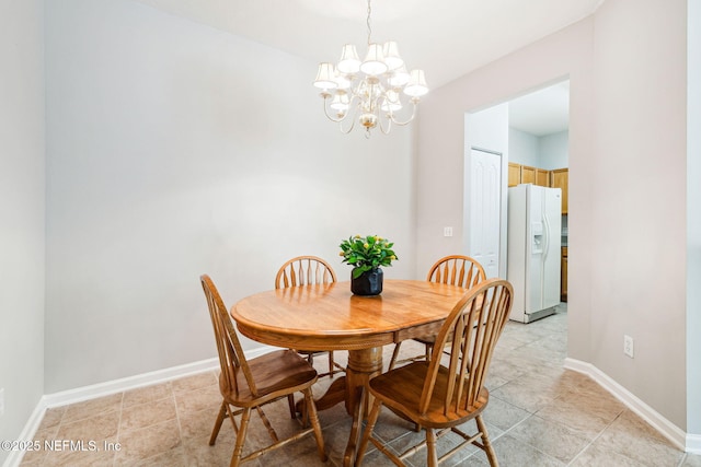 dining area featuring baseboards and a chandelier