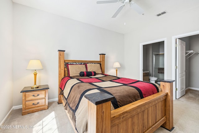 bedroom with baseboards, visible vents, connected bathroom, light colored carpet, and a spacious closet