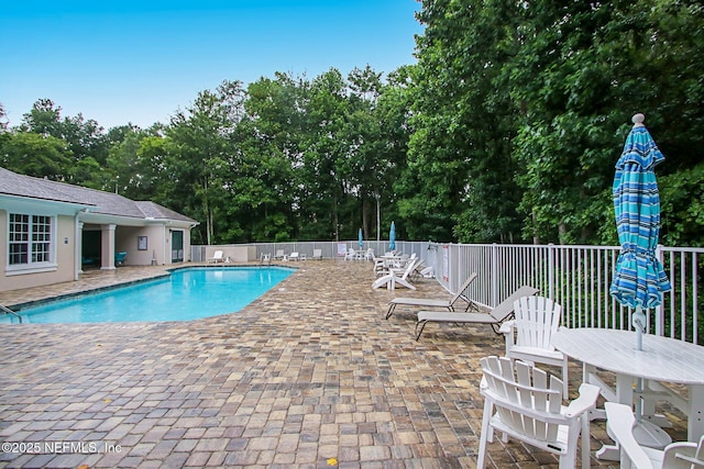 community pool featuring fence and a patio