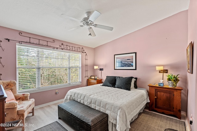 bedroom with lofted ceiling, ceiling fan, baseboards, and wood finished floors